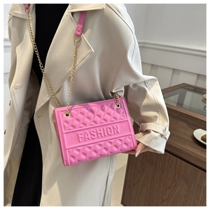 Detail of pink quilted shoulder bag with gold chain strap and embossed FASHION lettering