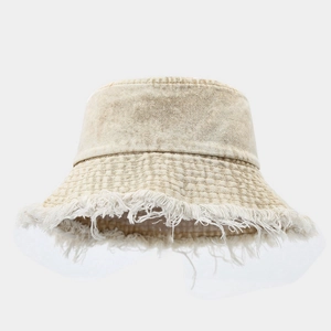 Détails des bords effilochés et franges d'un chapeau bob en jean beige de style urbain