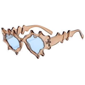 Futuristic punk sunglasses with wavy translucent brown frames and blue lenses on white