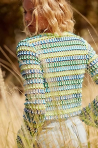 Détail du haut en crochet bleu et vert montrant une texture ondulée ajourée unique