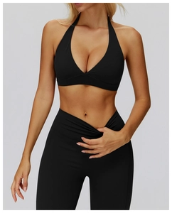 Close-up of black yoga set featuring halter neck bra and cross-waist leggings detail
