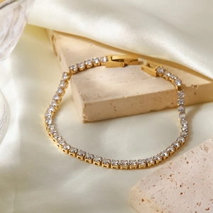 Dettaglio di un bracciale in zircone placcato oro 18K su pietra con seta di lusso