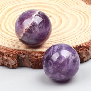 Polished natural amethyst crystal spheres on wooden base with beautiful violet mineral textures