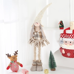 Detail of Christmas gnome plush featuring retractable striped legs and Merry banner
