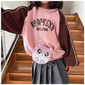 Détail d'un joli sac à bandoulière chat rose porté par une petite fille en sweat à capuche