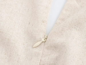 Détail d'une fermeture éclair invisible beige sur une robe en mélange de lin