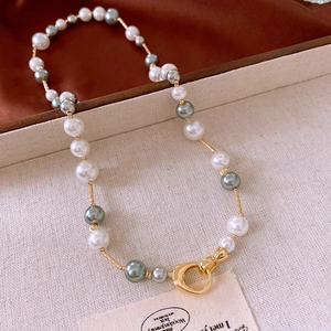 Détail d'un collier de perles en verre vintage avec accents dorés en boîte à bijoux