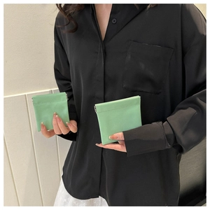 Close-up of bright green square mini storage bags with metal snap closure for women
