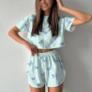 Detail of mint green two-piece set featuring jacquard eyelet fabric and purple butterflies