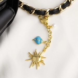 Gold sun pendant keychain with blue shell and pearl charms on braided leather chain