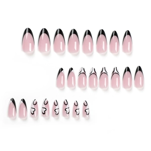 Long almond press-on nails with nude base, black French tips and heart graffiti patterns