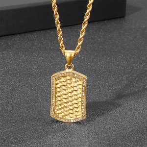 Close-up of gold punk style military tag pendant with micro-diamonds and rope chain