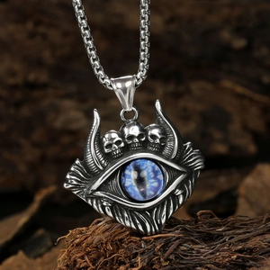 Detail of silver skull evil eye pendant with blue inlay on a wooden background