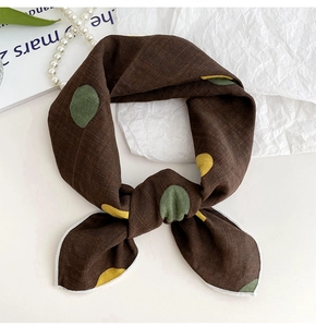 Detailed texture of brown polka dot cotton linen neck scarf with white stitching edges