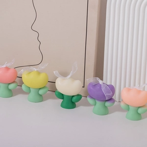Close-up of tulip-shaped scented candles in multiple macaron colors with ribbon details