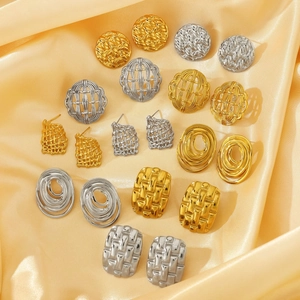 Macro view of vintage hammered gold and silver irregular textured square stud earrings