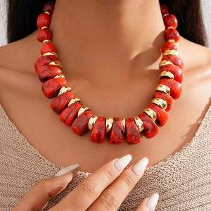 Close-up of red marble acrylic beads and golden metal spacers on a choker necklace