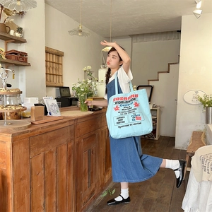 Lifestyle view of large blue canvas tote bag with vintage print for daily casual outfits