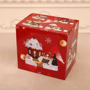 Detail of red Christmas music box featuring rotating train and glowing festive scenes