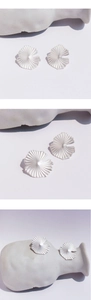 Macro detail of matte silver ginkgo leaf earrings with a delicate textured surface finish