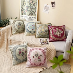 Vintage floral embroidered square pillows in various colors on a cozy sofa setting