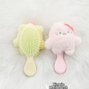 Close-up of cute monster plush hairbrushes in yellow and pink with soft massage air cushion