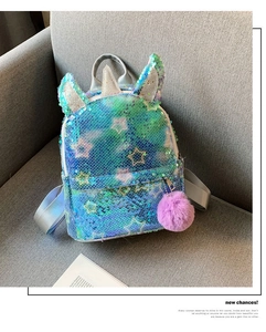 Detail of sequin unicorn backpack with blue-green stars and a purple faux fur pompom
