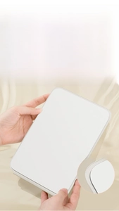 Detail of rounded polished edges on a portable folding mirror with a white frame
