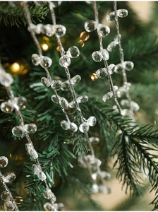 Gros plan d'un pendentif en perles de cristal sur sapin de Noël avec lumière bokeh