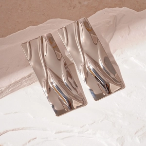 Detail of silver geometric rectangular earrings with liquid metal texture on stone