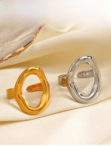 Close-up of gold and silver irregular oval open rings on soft beige satin fabric