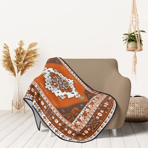 Detail of bohemian orange flannel throw blanket with geometric patterns on a chair