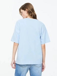 Vista posteriore di una t-shirt oversize in cotone azzurro che mostra il taglio