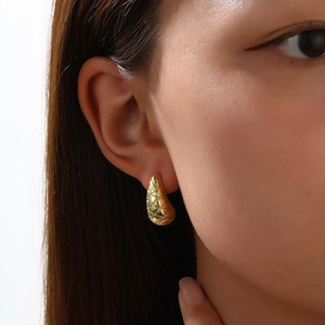 Detailaufnahme der 18k vergoldeten Tropfenohrstecker mit elegantem Steppmuster Dekor