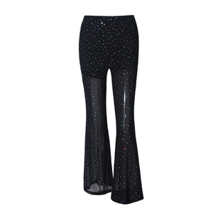 Detail of black sheer mesh trousers with colorful rhinestones and flared leg silhouette