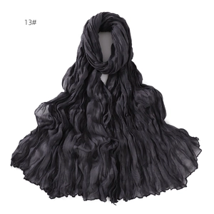 Detail of pure black lightweight scarf showing intricate crinkle pleated texture fabric