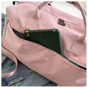 Detailed front zipper pocket of pink sports bag showing tablet storage capacity