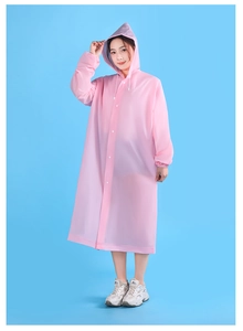 Detailed view of pink translucent EVA raincoat with hood and snap buttons on blue background