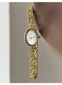 Gros plan détaillé d'une montre ovale dorée vintage avec bracelet chaîne à strass