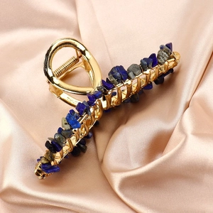 Close-up of gold alloy hair claw clip with inlaid blue lapis lazuli natural crystal stones