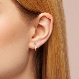 Close-up of minimalist gold S925 sterling silver hoop earring with single diamond on model