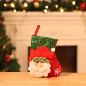 Close-up of a red plush Christmas stocking with green sequins and a 3D Santa Claus figure