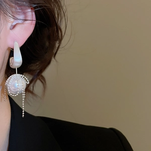 Macro detail of silver needle pearl drop earrings with elegant beaded tassel fringes