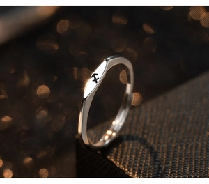 Macro shot of silver Sagittarius zodiac symbol ring with warm bokeh light background