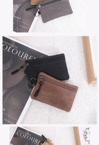 Flat lay of canvas coin purses in black, brown, and grey with metal rings and zippers