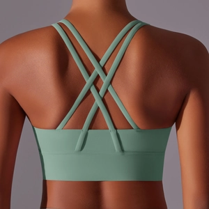 Dettaglio del reggiseno sportivo verde salvia con spalline incrociate e tessuto elastico