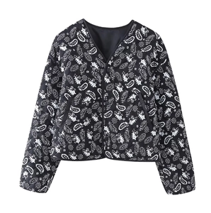 Detail of V-neck quilted jacket featuring black and white paisley floral pattern texture