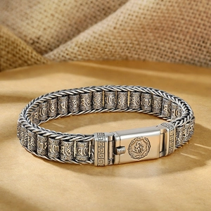 Gros plan détaillé du bracelet rétro pour homme avec des cylindres gravés du mantra