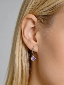 Close-up of S925 sterling silver hoop earring with purple zircon pendant worn on ear