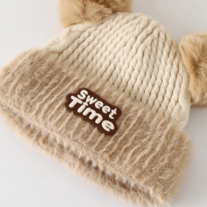 Dettaglio del cappello invernale con trama in maglia e pompon soffici